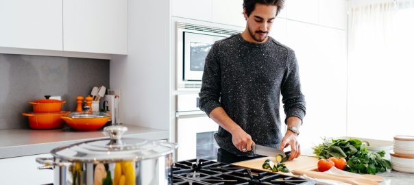 A man chopping vegetables at a kitchen counter