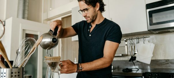A man making pour-over coffee in his kitchen